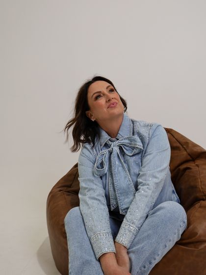 Lisa Bondarenko in denim, seated.