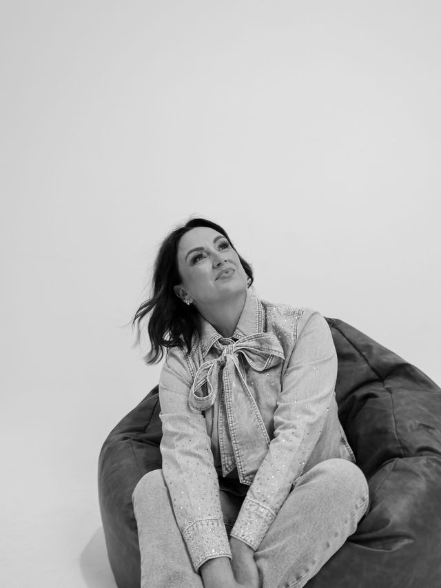 Lisa Bondarenko seated, in black and white.